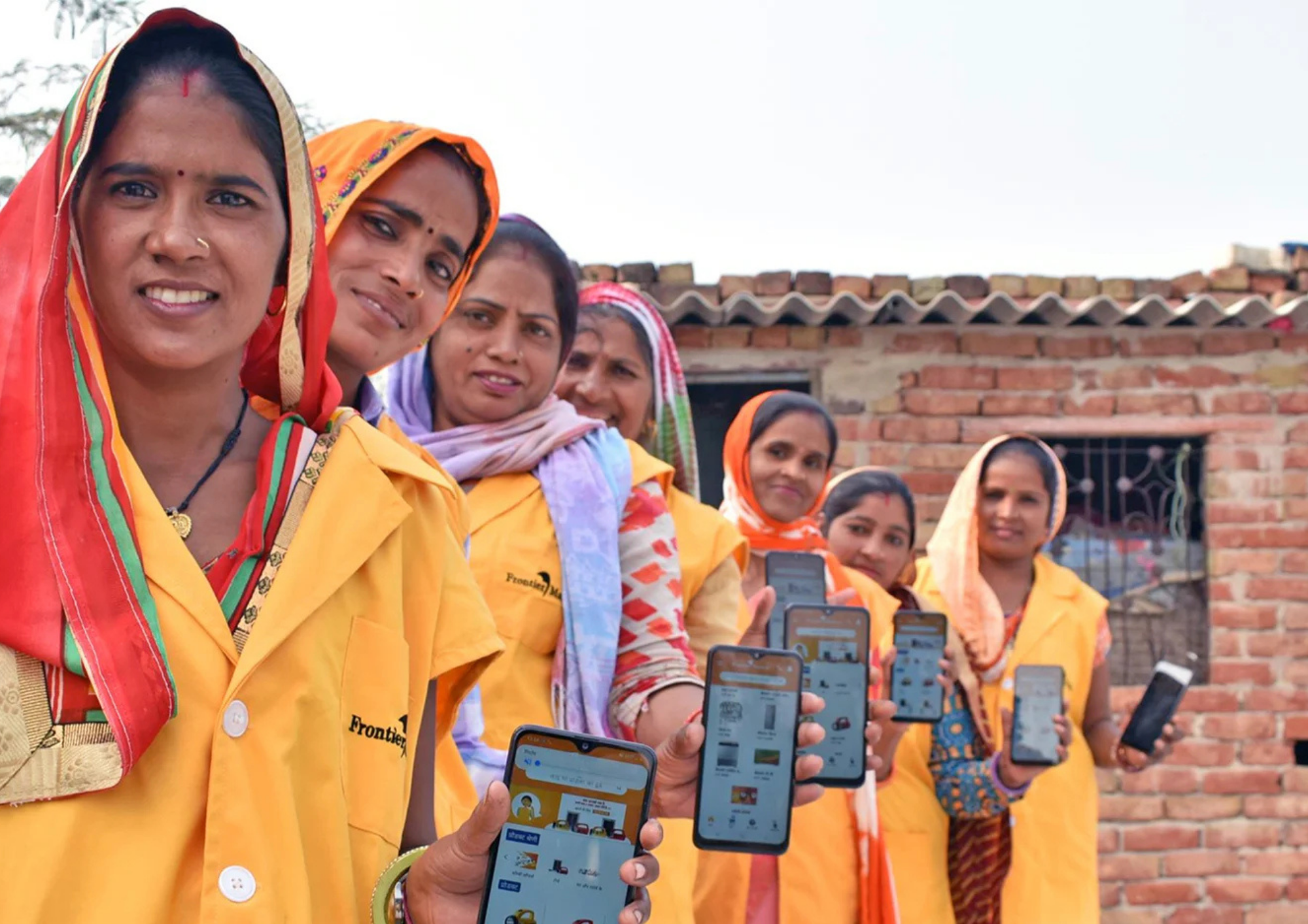 Frontier Markets' team showing the app on their mobile phone