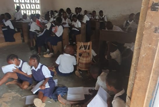 Children studying on the floor of a classroom