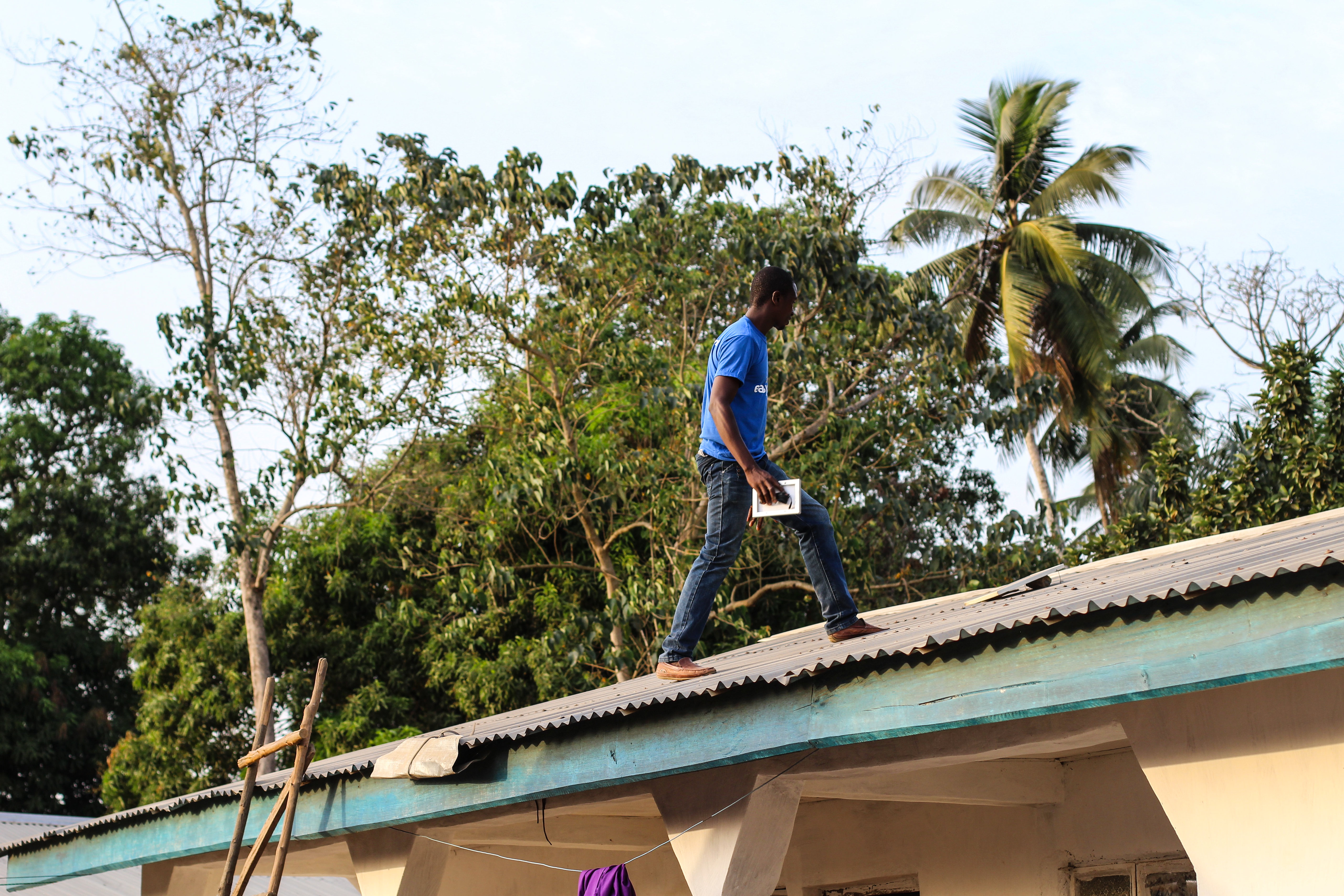 Person in a roof carrying a solar panel