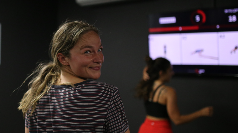 Girl smiling in front of TV running CloudFit