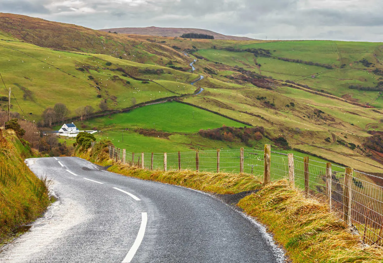 A quiet road winds through the green hills.
