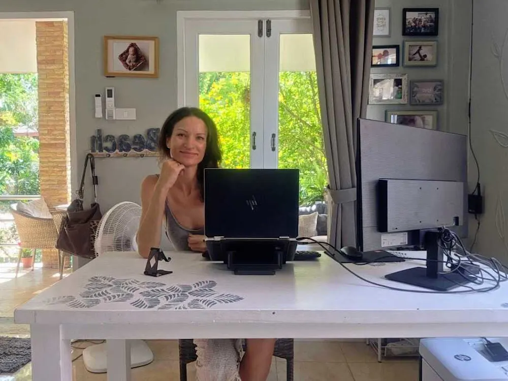 A second screen, laptop, and essentials—Kaila's remote setup is built for reliability.