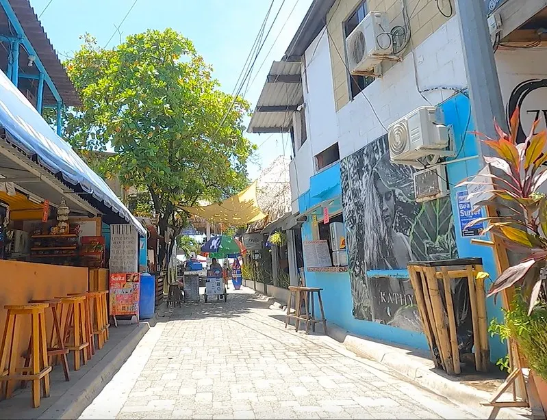 Sunny street in El Tunco, El Salvador, with vibrant murals and cozy cafes capturing the beachside vibe.