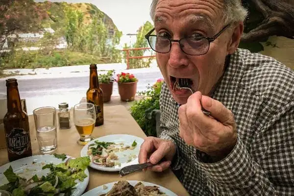 Rich's first, uncertain bite of goat, Ikaria.