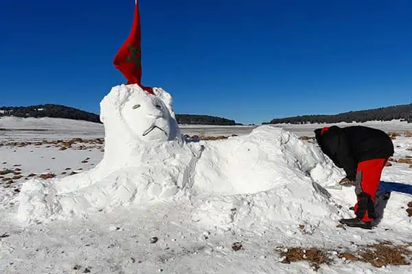 A Moroccan man puts the finishing touches to his larger-than-life snow lion sculpture just outside Ifrane, an alpine-style town set amongst the Middle Atlas Mountains. ©David Gibb