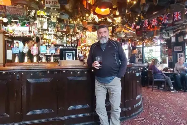 Tim enjoying a cold beer in the cozy interior of The Churchill Arms.