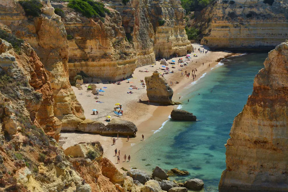 Copper cliffs and a heart-shaped sea arch define this Algarve gem.
