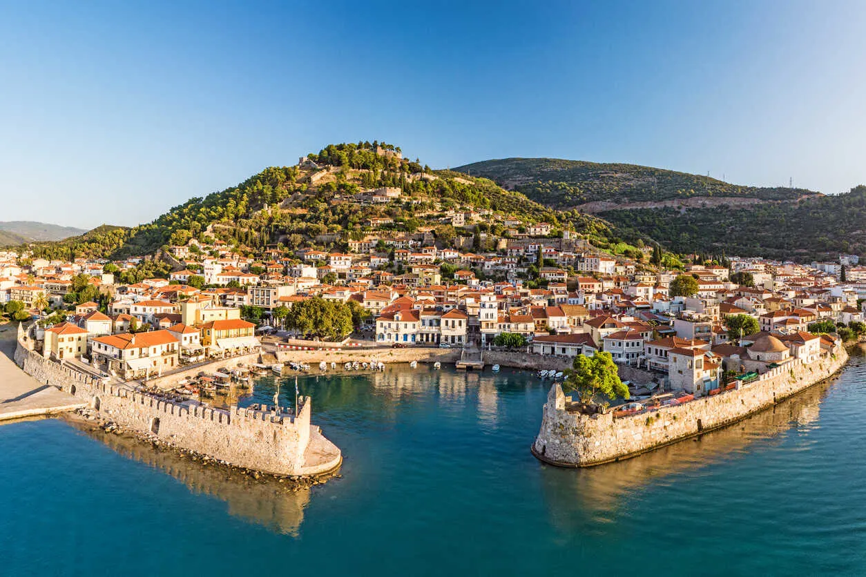 A stone harbor and castle overlook daily life in Nafpaktos.