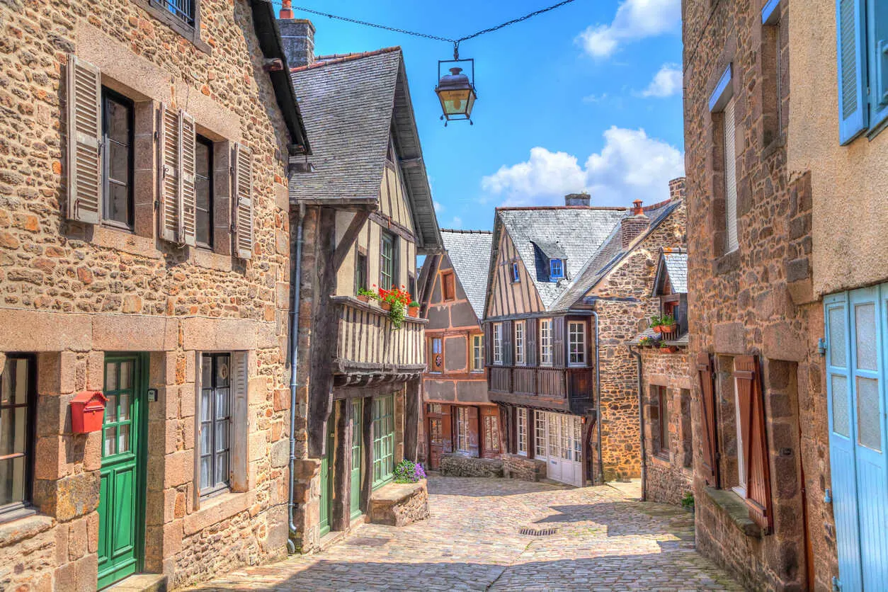 Narrow street with old traditional houses in histoical part of Dinan, Brittany, France.