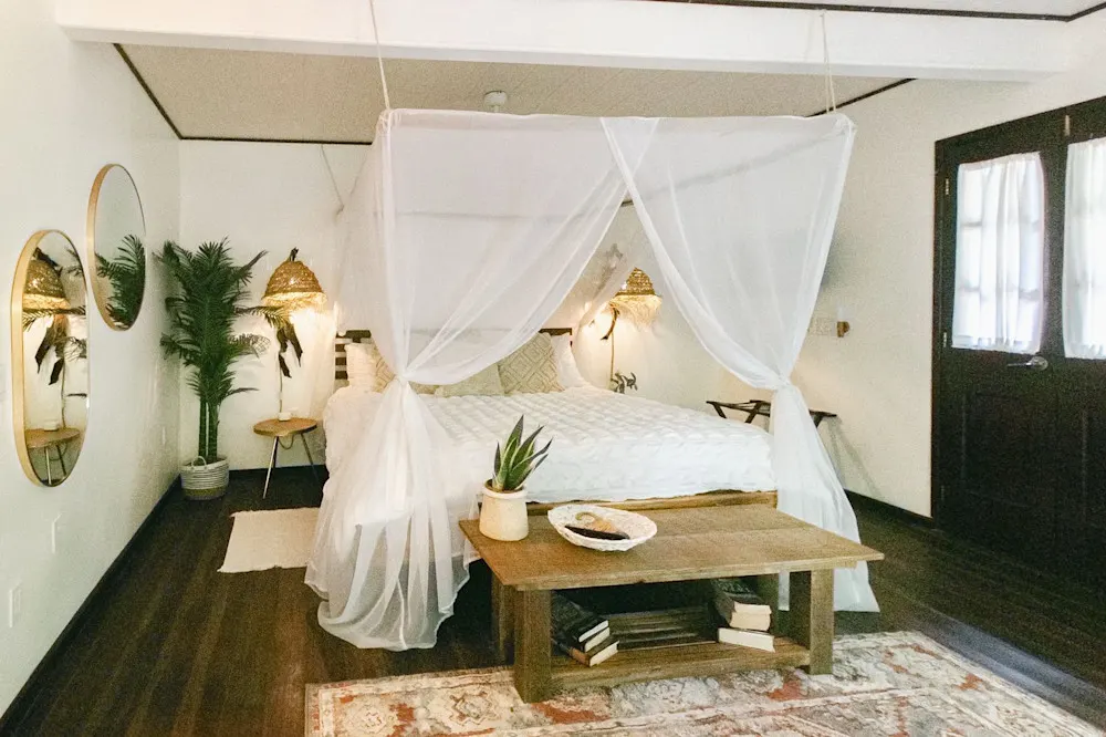 Barefoot luxury on a budget: thrifted finds, mosquito net canopies, and high-quality linens.