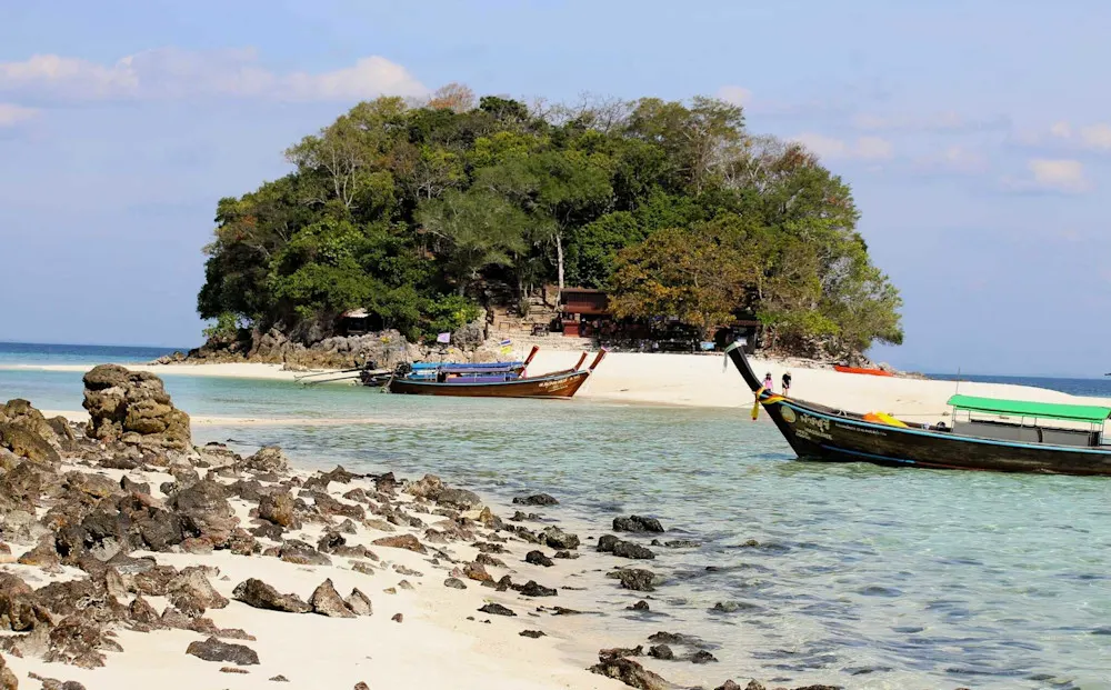 Longtail boats at a pristine Krabi island—turquoise waters and soft sand.