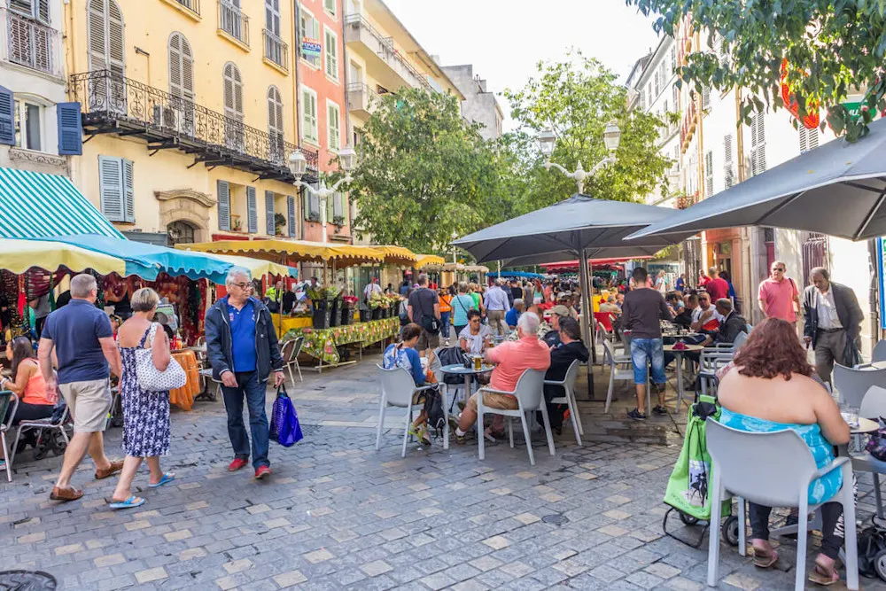 Locals shop and relax at cafés along Toulon’s bustling Cours Lafayette market street.