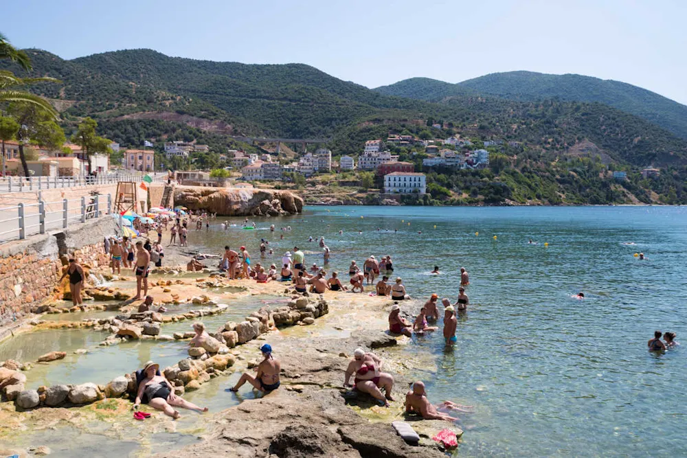Locals soak in Edipsos’s free seaside hot springs under open skies.