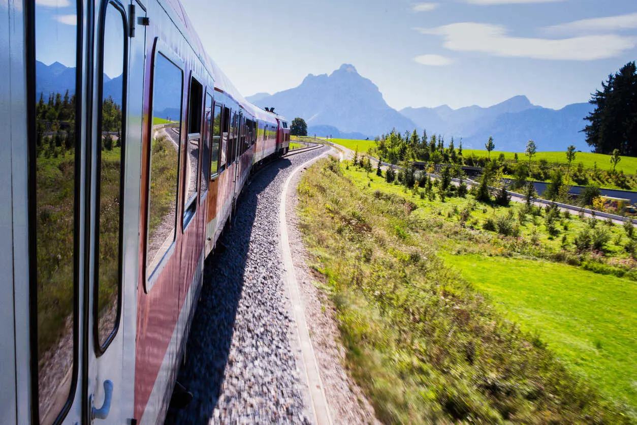 A scenic regional train glides through Bavaria’s Alpine foothills en route to adventure.