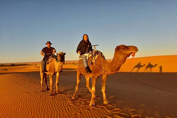 David and Beverley saddle up to take a dromedary (also known as the Arabian camel) ride across the sands of Morocco’s Sahara Desert, near Erg-Chebbi. ©David Gibb