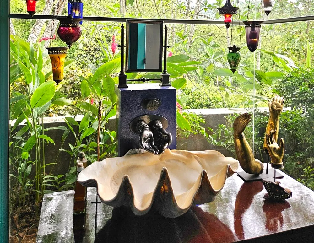 Master bathroom sink made from a maneater clam shell, with water flowing from bronze hands cast from my own.