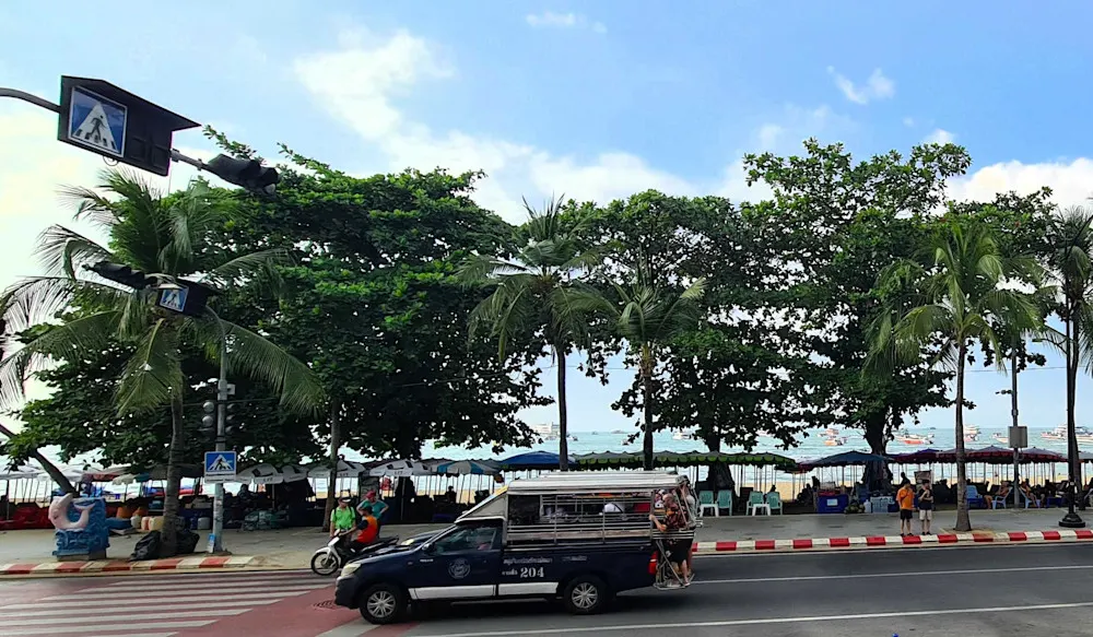 A baht bus passes along Pattaya Beach.