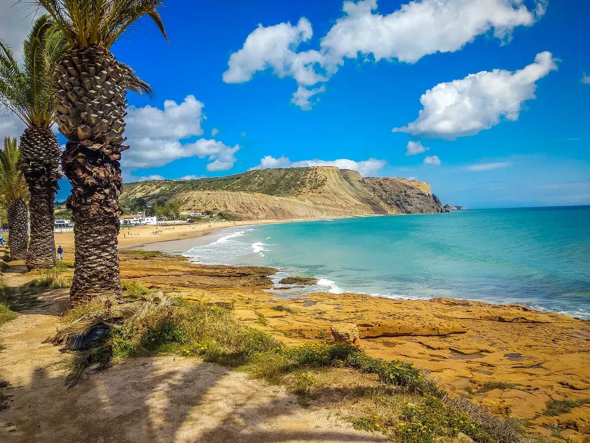 Praia da Luz: a serene beach framed by rugged cliffs in the Algarve.