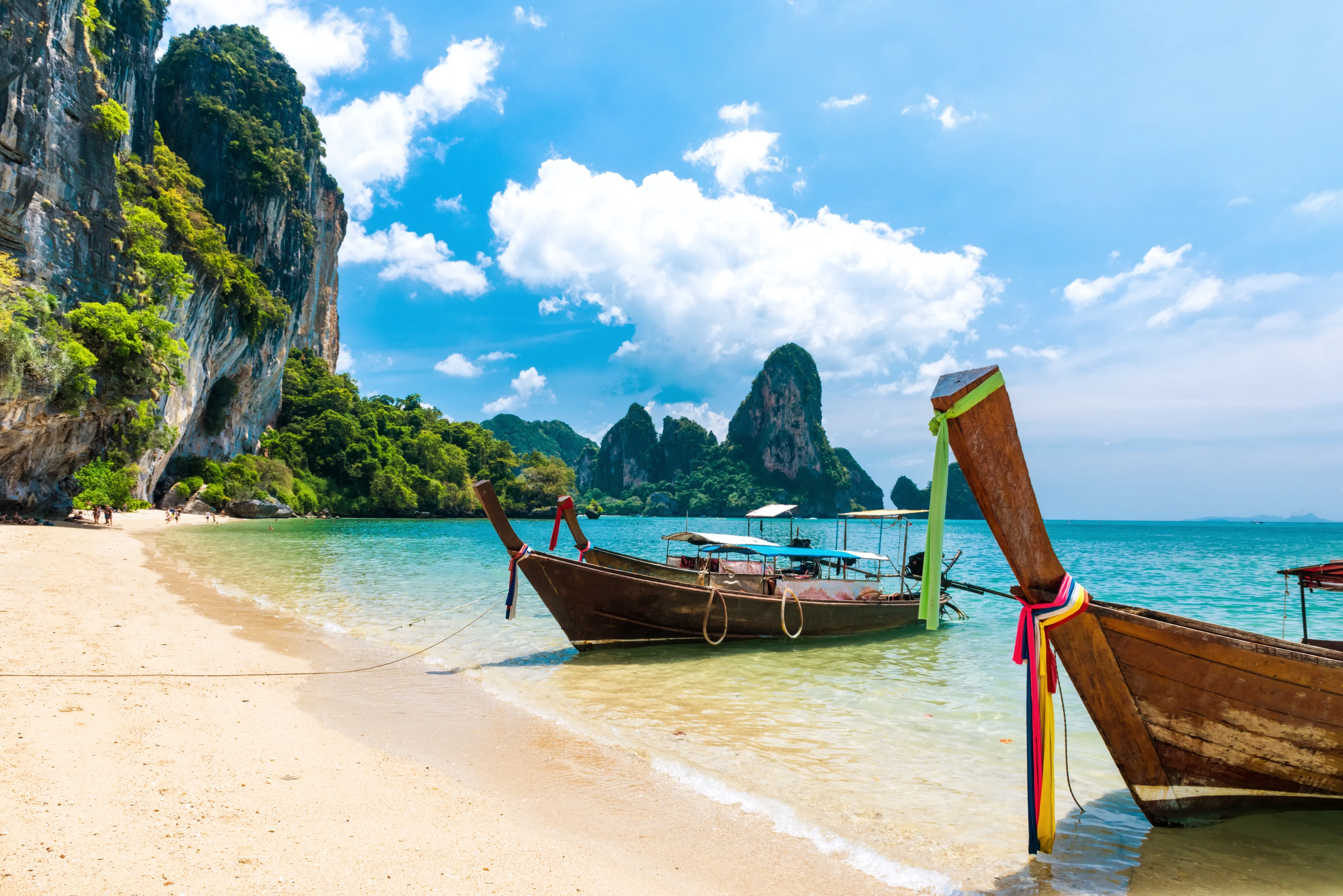 Strand i Thailand med två träbåtar vid strandkanten