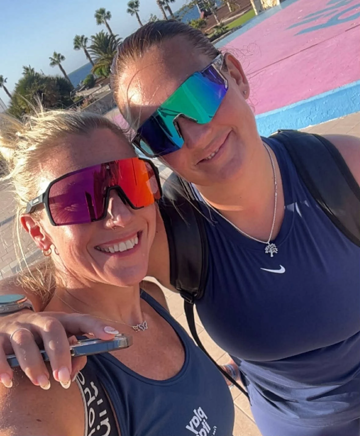 Bilde av Louise og Elin med treningssolbriller med en rosa plattform i bakgrunnen.