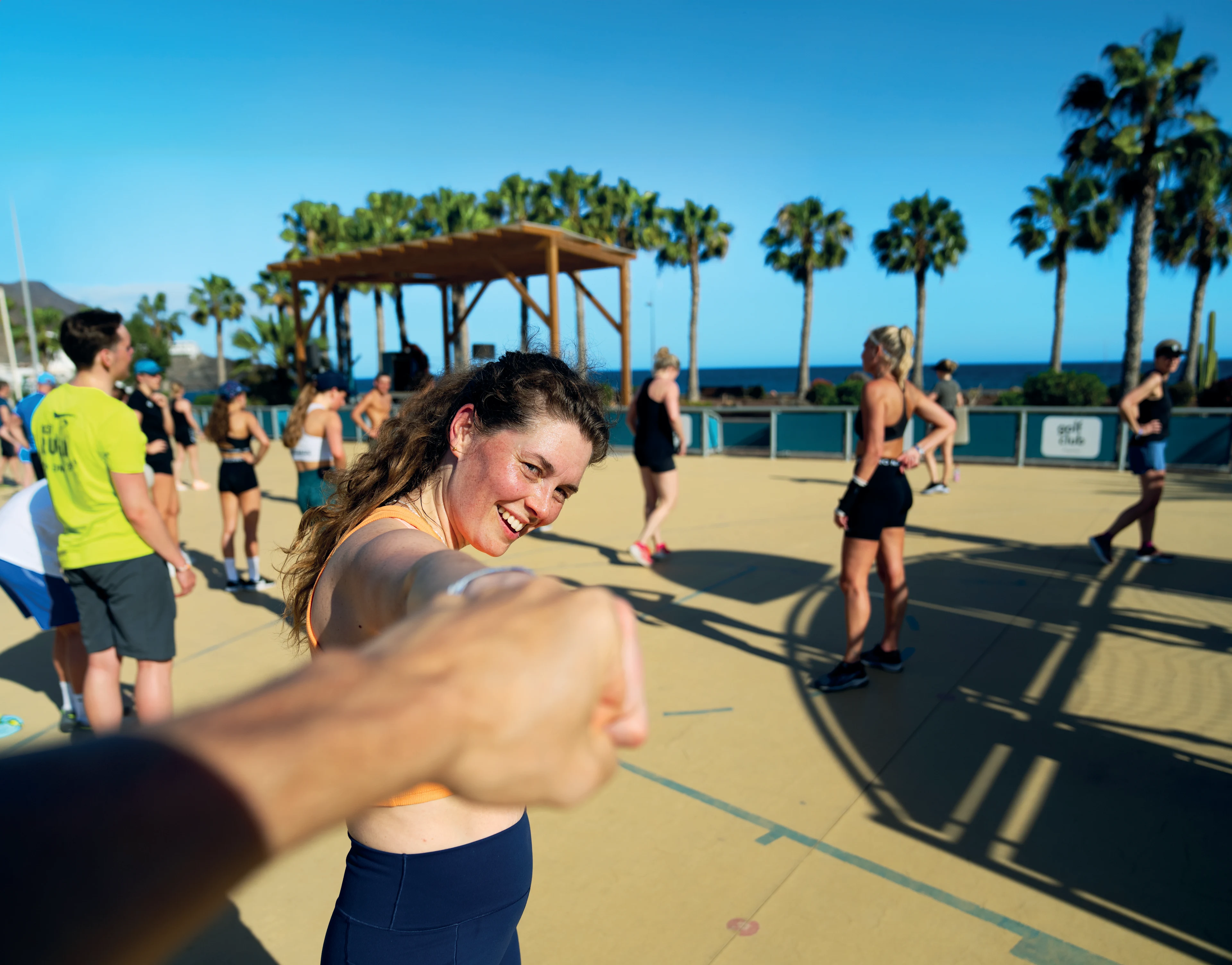 To personer laver fistbump under træning på en multicourt under blåhimmel på Playitar, Fuerteventura.
