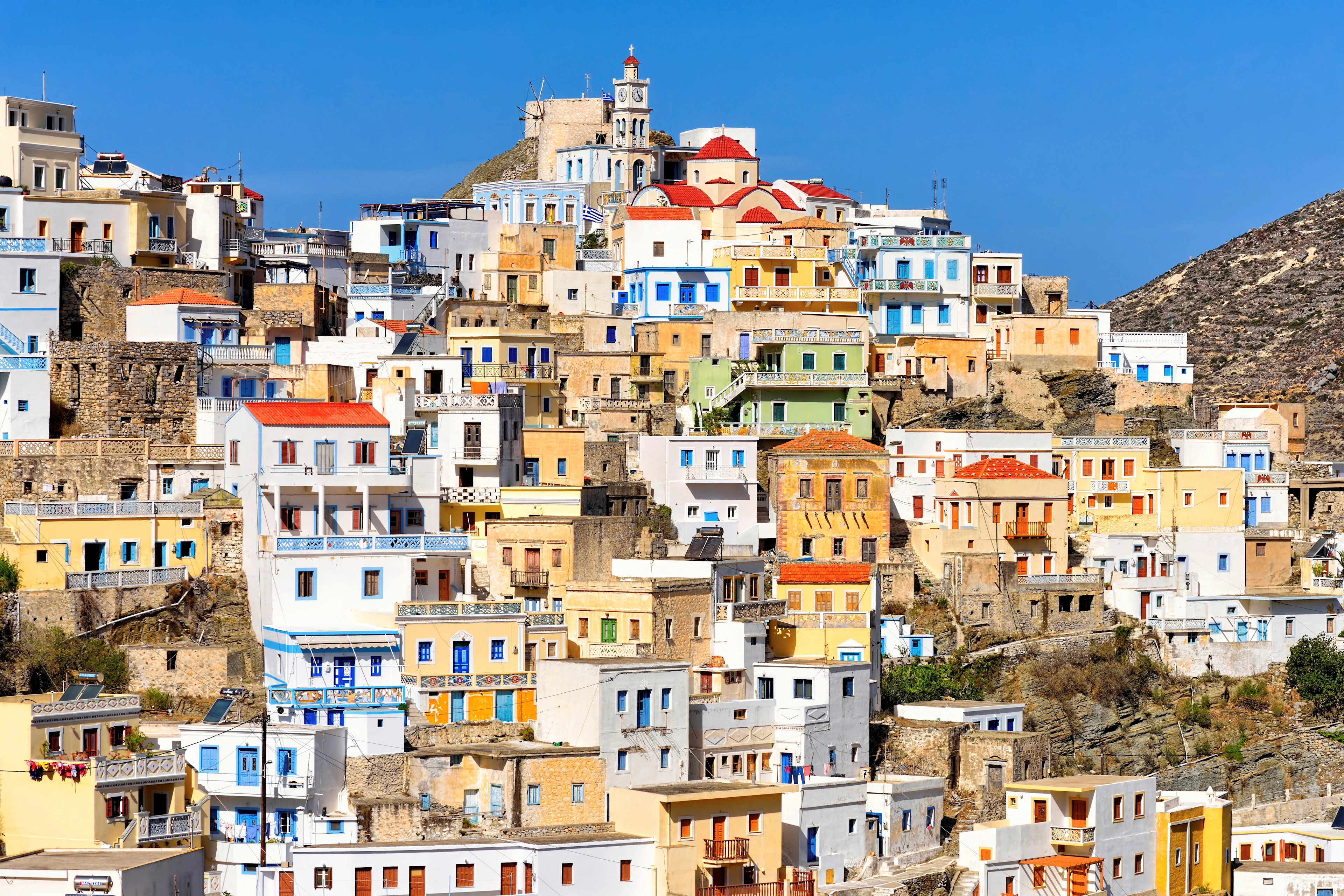 Utsikt över Olympos på Karpathos, där färgglada hus klättrar längs bergssluttningen under klarblå himmel
