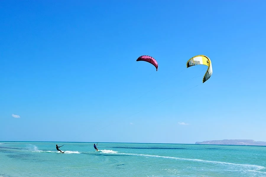 Twee kitesurfers op turquoise water in Egypte