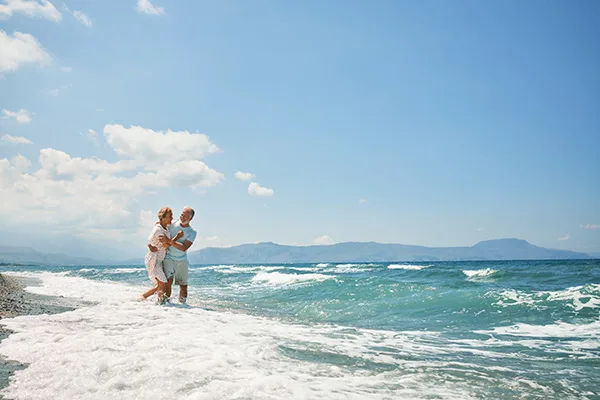 Par står i vandet på en strand