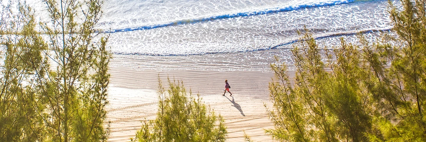 En mann som vandrer i strandkanten