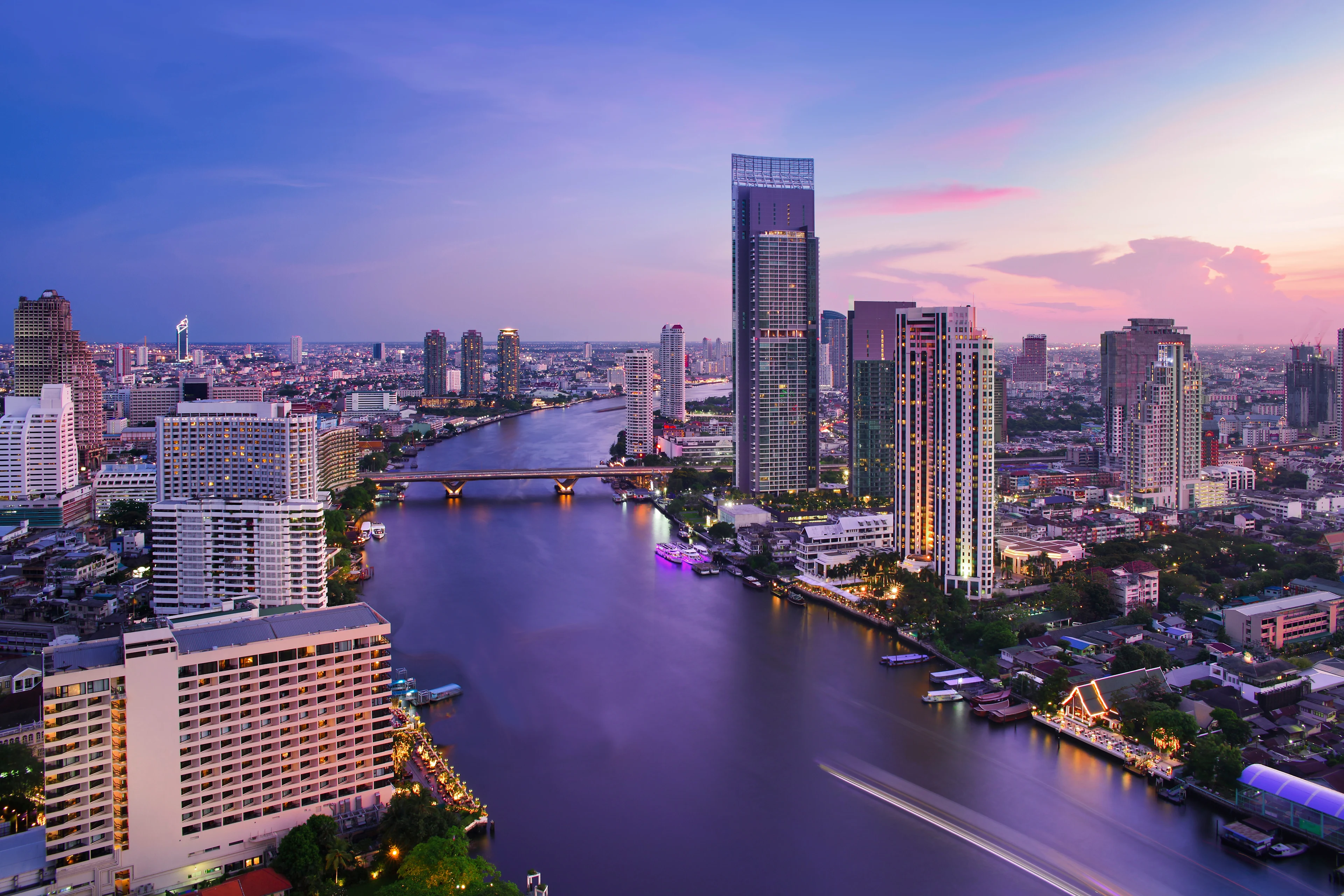 Bangkokin vaikuttava siluetti auringonlaskun sekä Chao Phraya -joki
