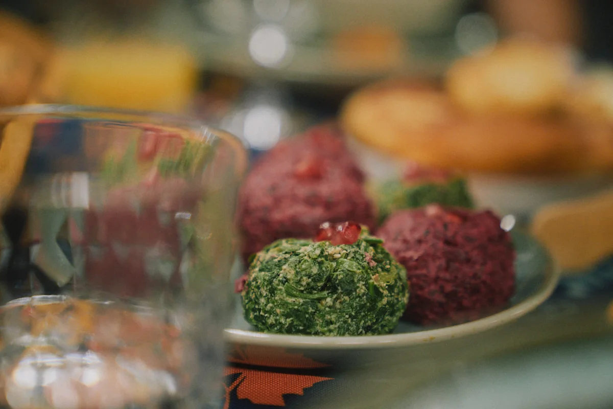 Tallerken med fargerike vegetarboller, brød og drikke på et dekket bord.
