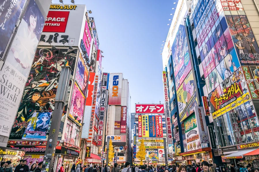 Travl gade i Tokyo med højhuse og farvestrålende reklameskilte