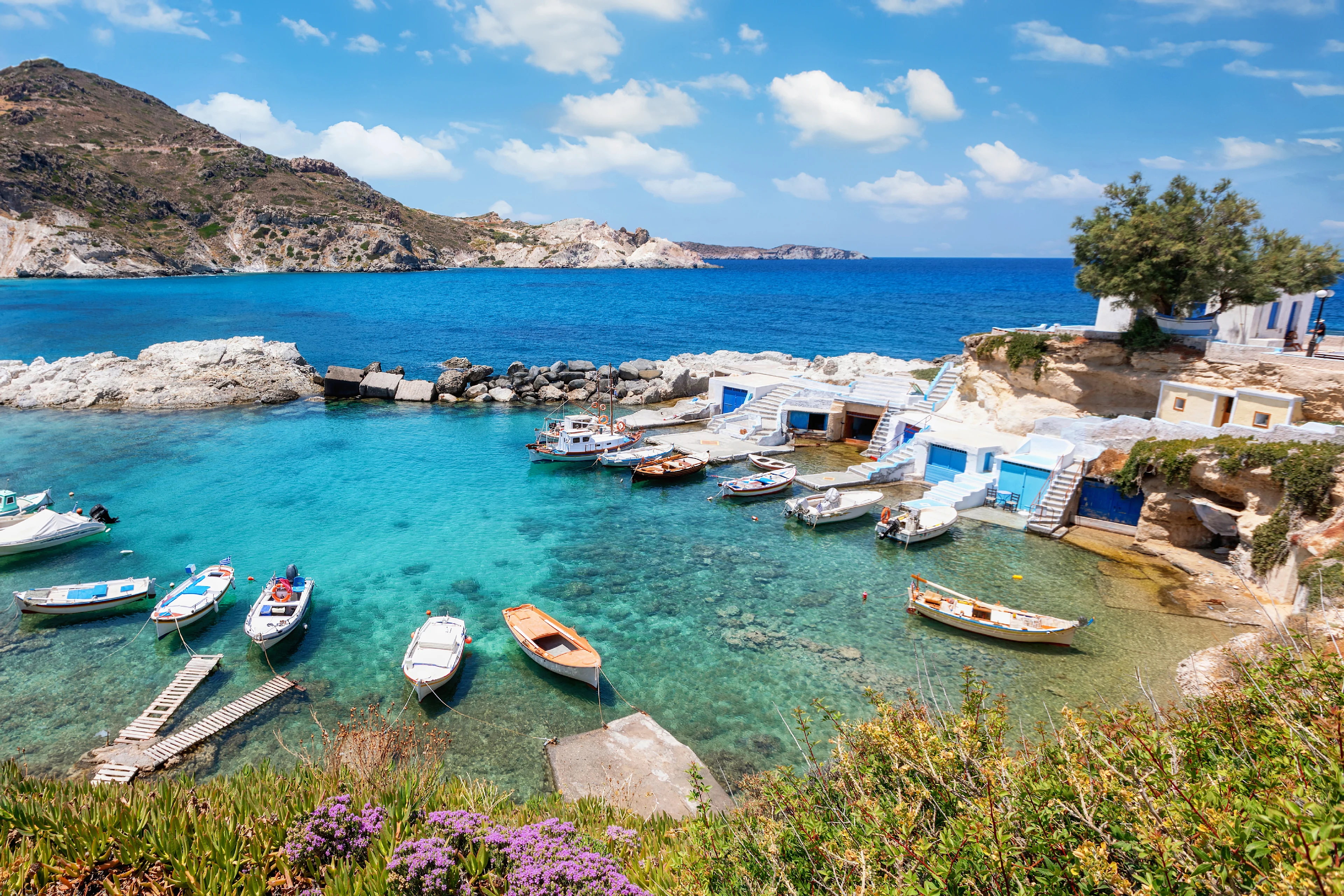 Små båter i en vakker liten havn på Milos i Hellas