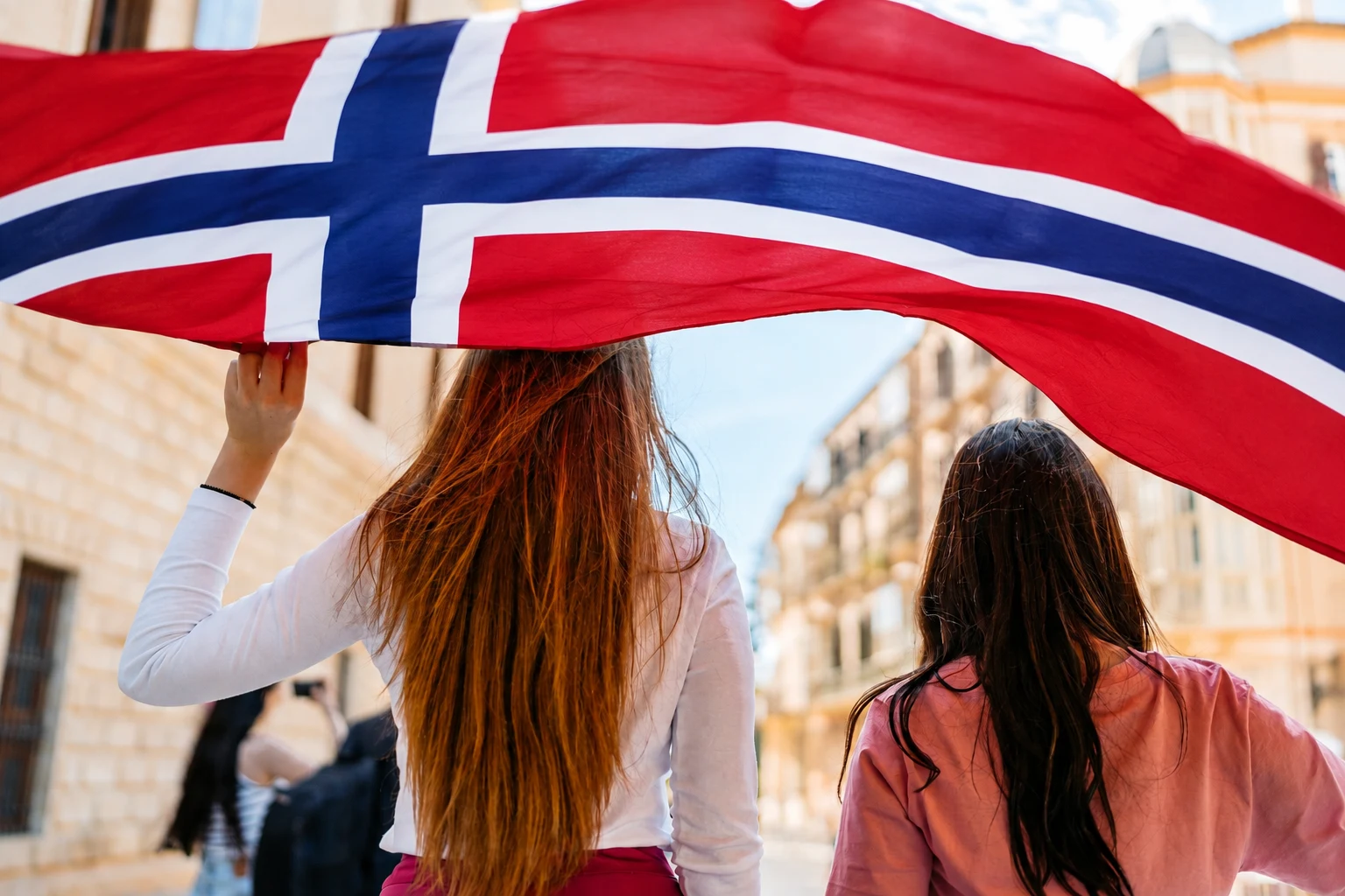 To kvinner bærer et norsk flagg