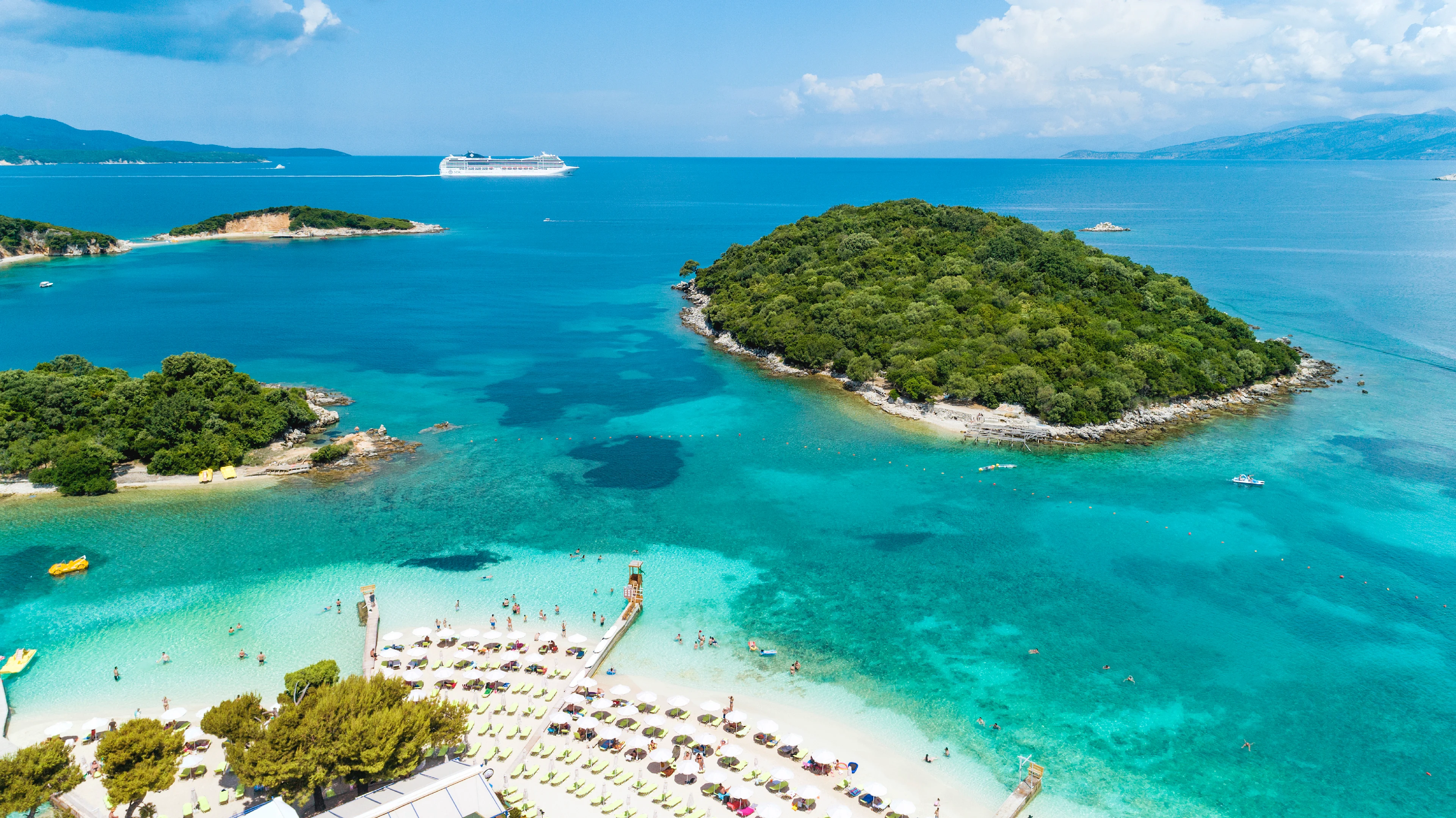 strand in Ksamil met ligbedden en parasols met kleine eilanden in zee