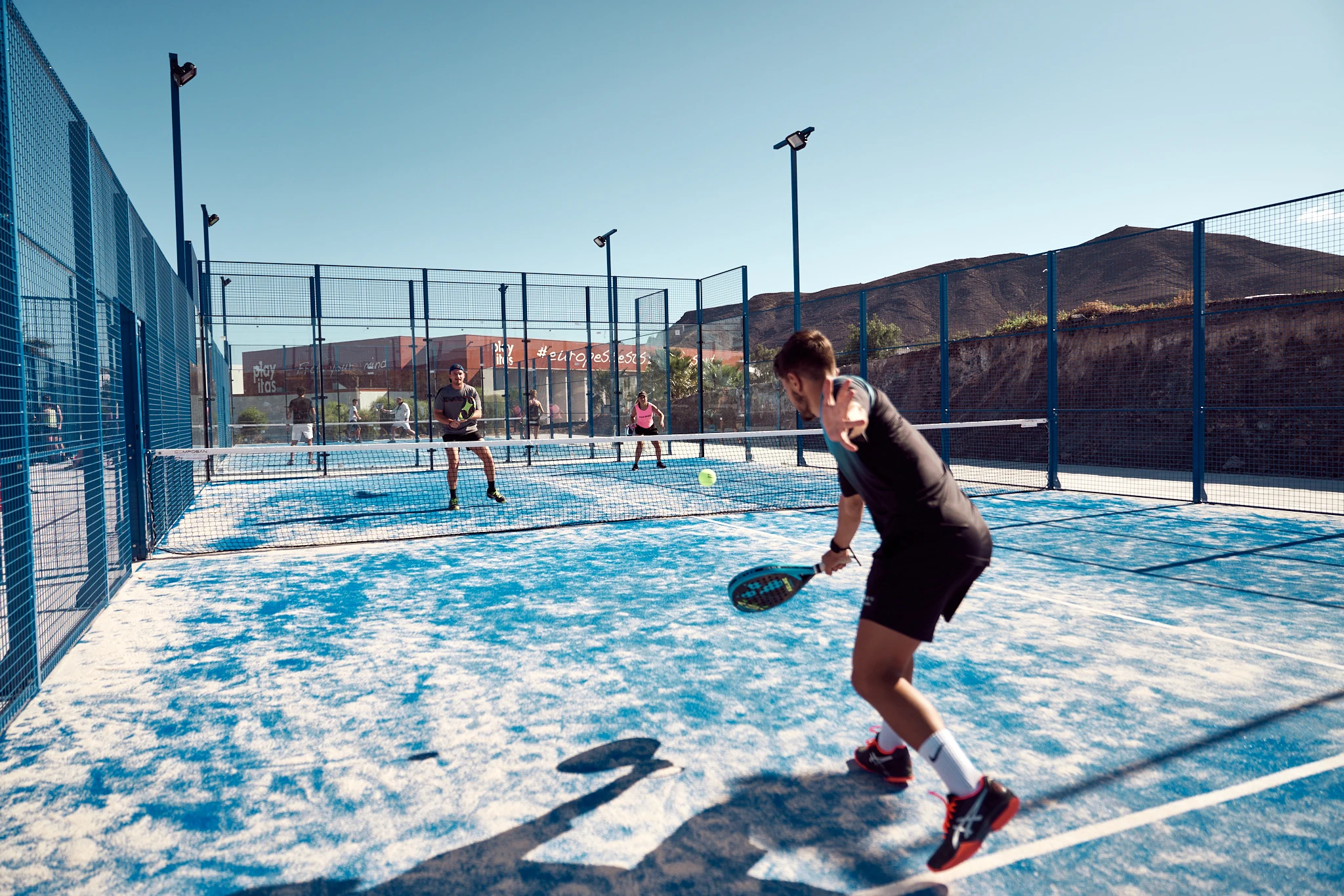 Padel på en blå padelbana