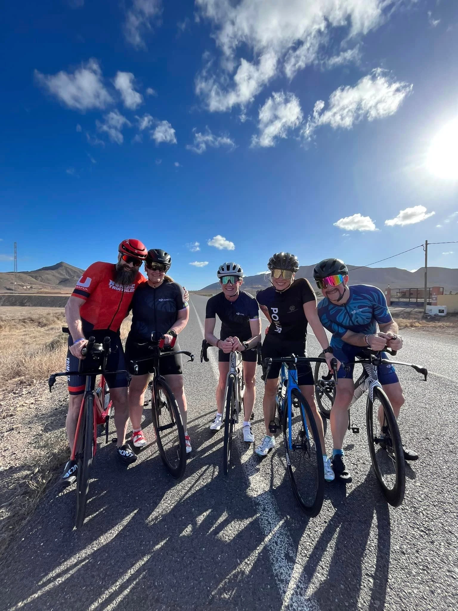 Människor på cyklar står vid sidan av en väg