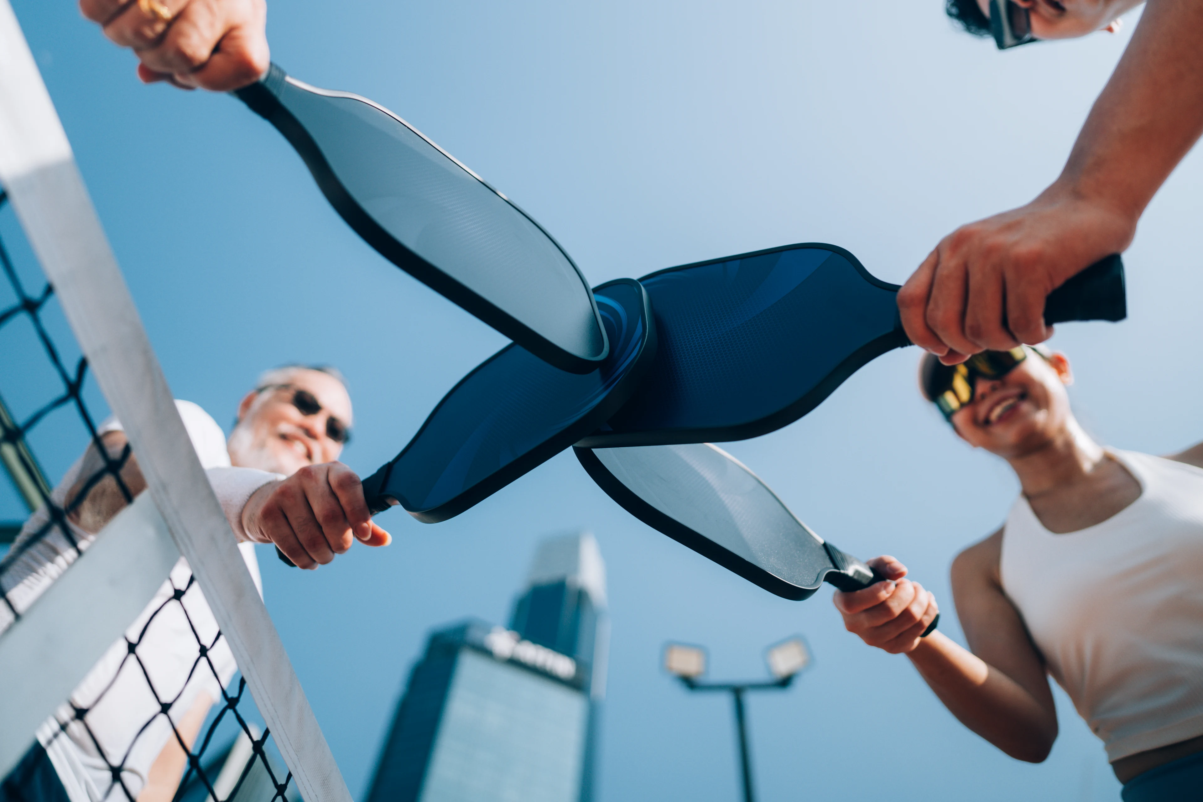En bild tagen från låg vinkel fångar fyra vuxna efter avslutad pickleballmatch