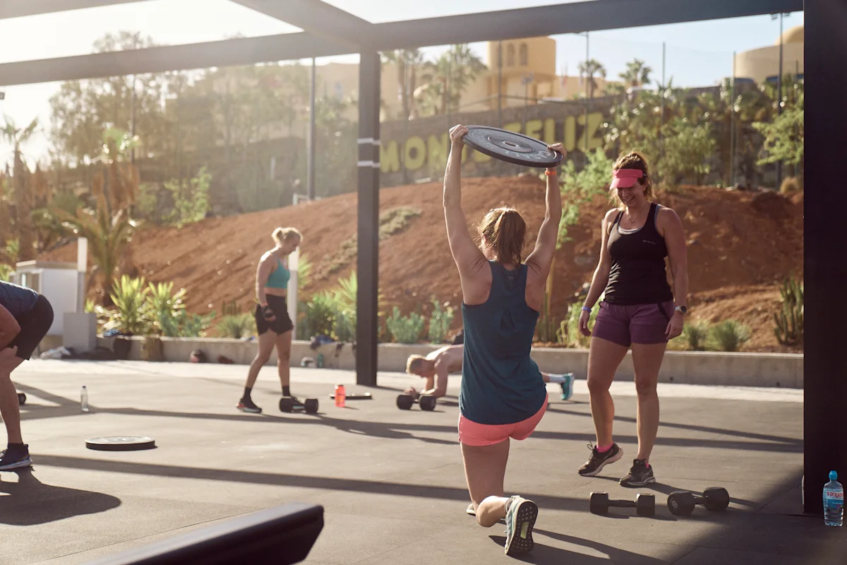 Kvinna som gör utfallssteg med viktplatta ovanför huvudet