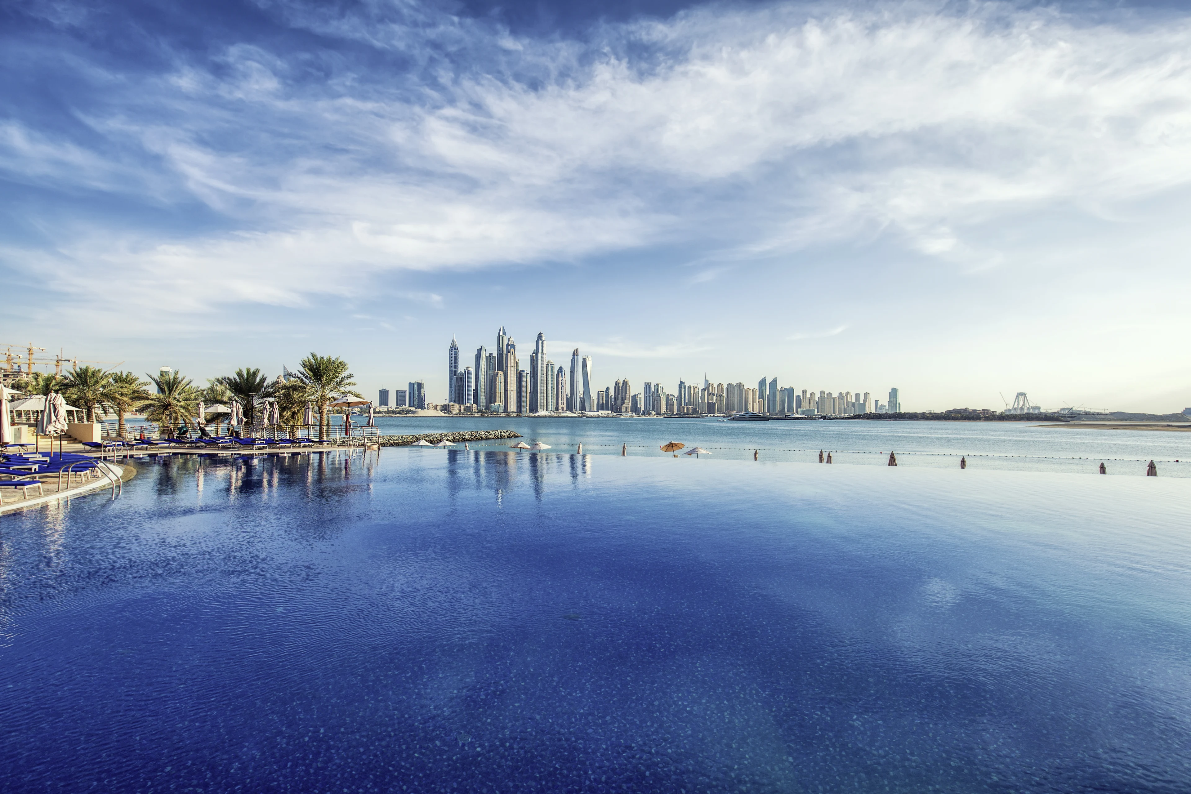 Utsikt över en infinitypool med dubais skyskrapor i bakgrunden