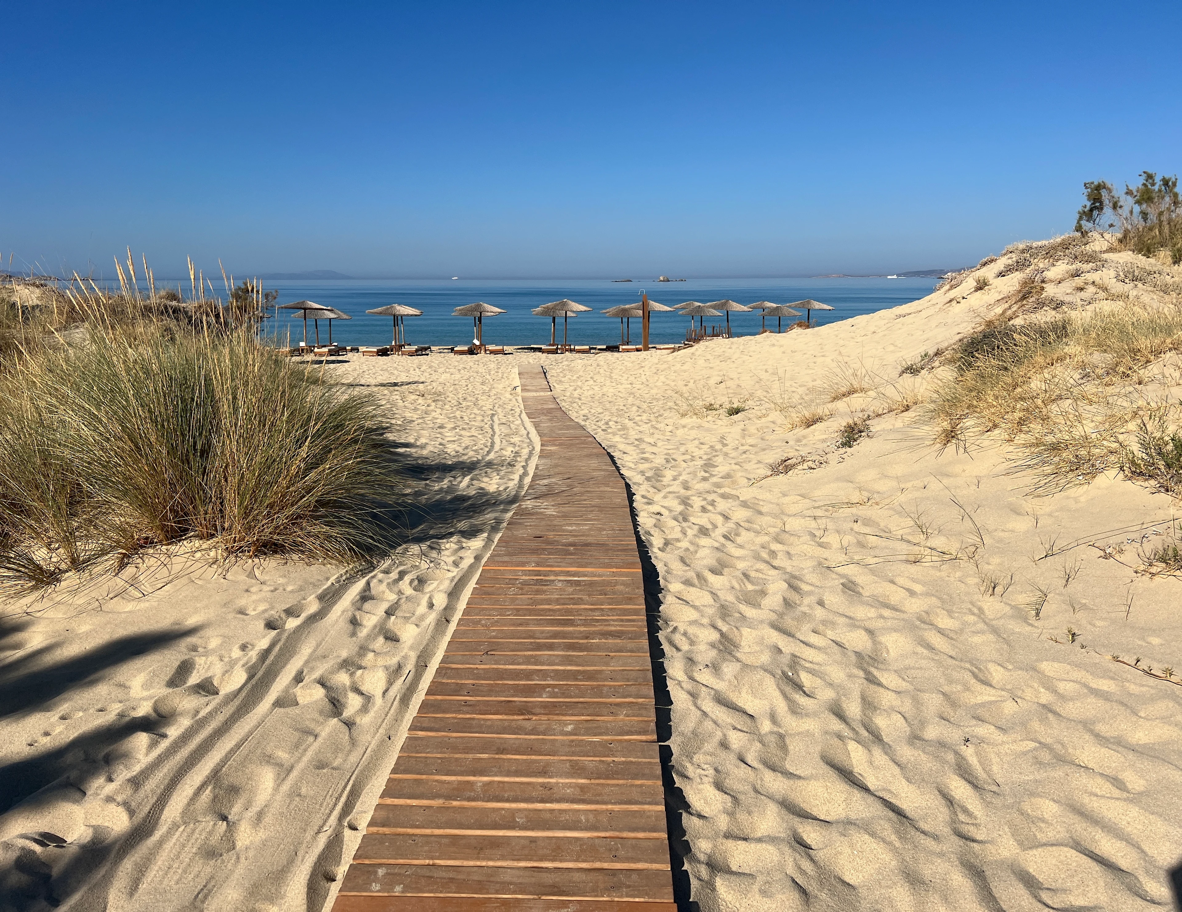 Gyldent sand og parasoller på Plaka Beach, Naxos