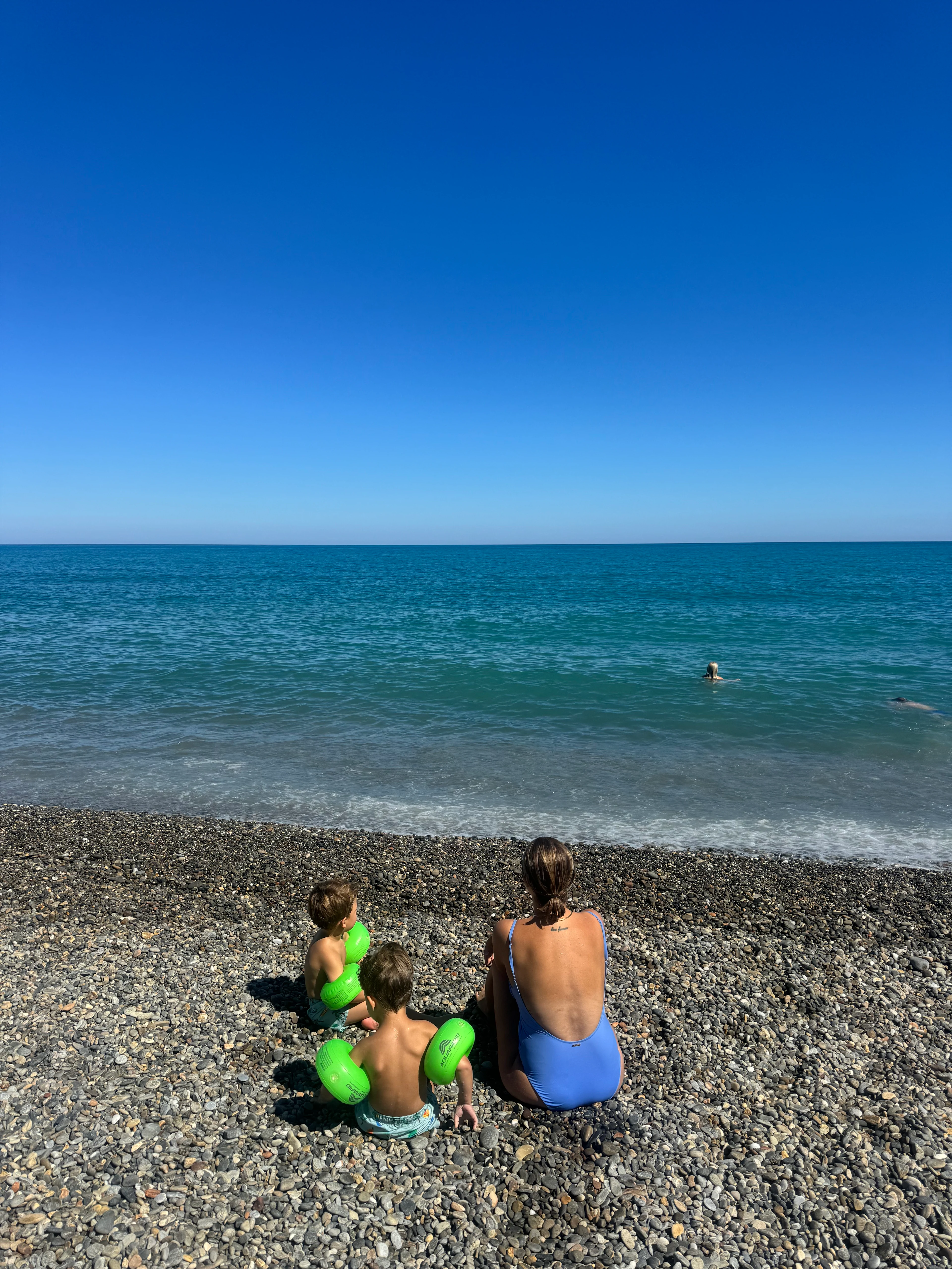 Evelina Sigetty och sina två söner på stranden vid Caldera Beach