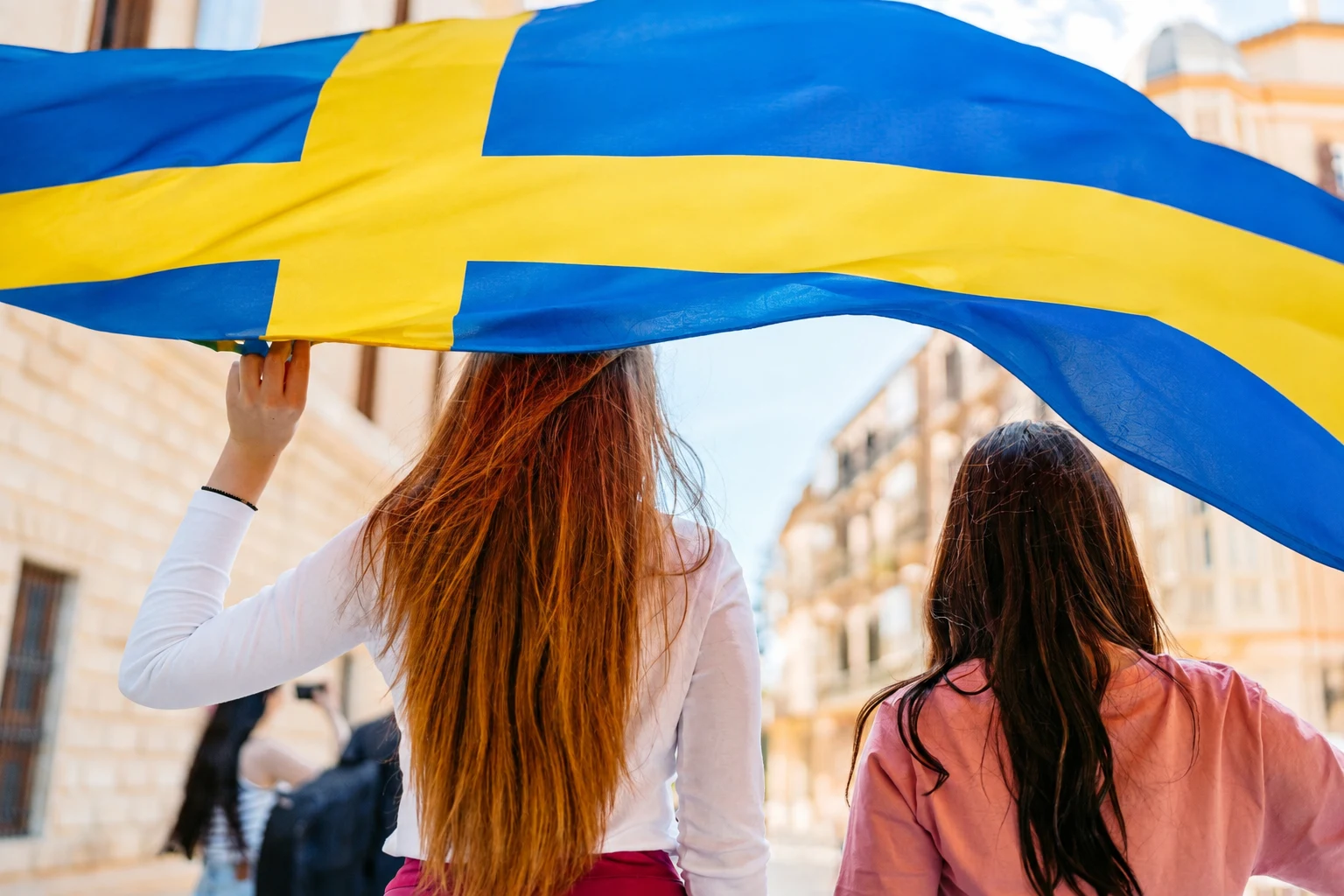 Svenska fotbollsspelare i gula landslagströjor firar tillsammans på planen.