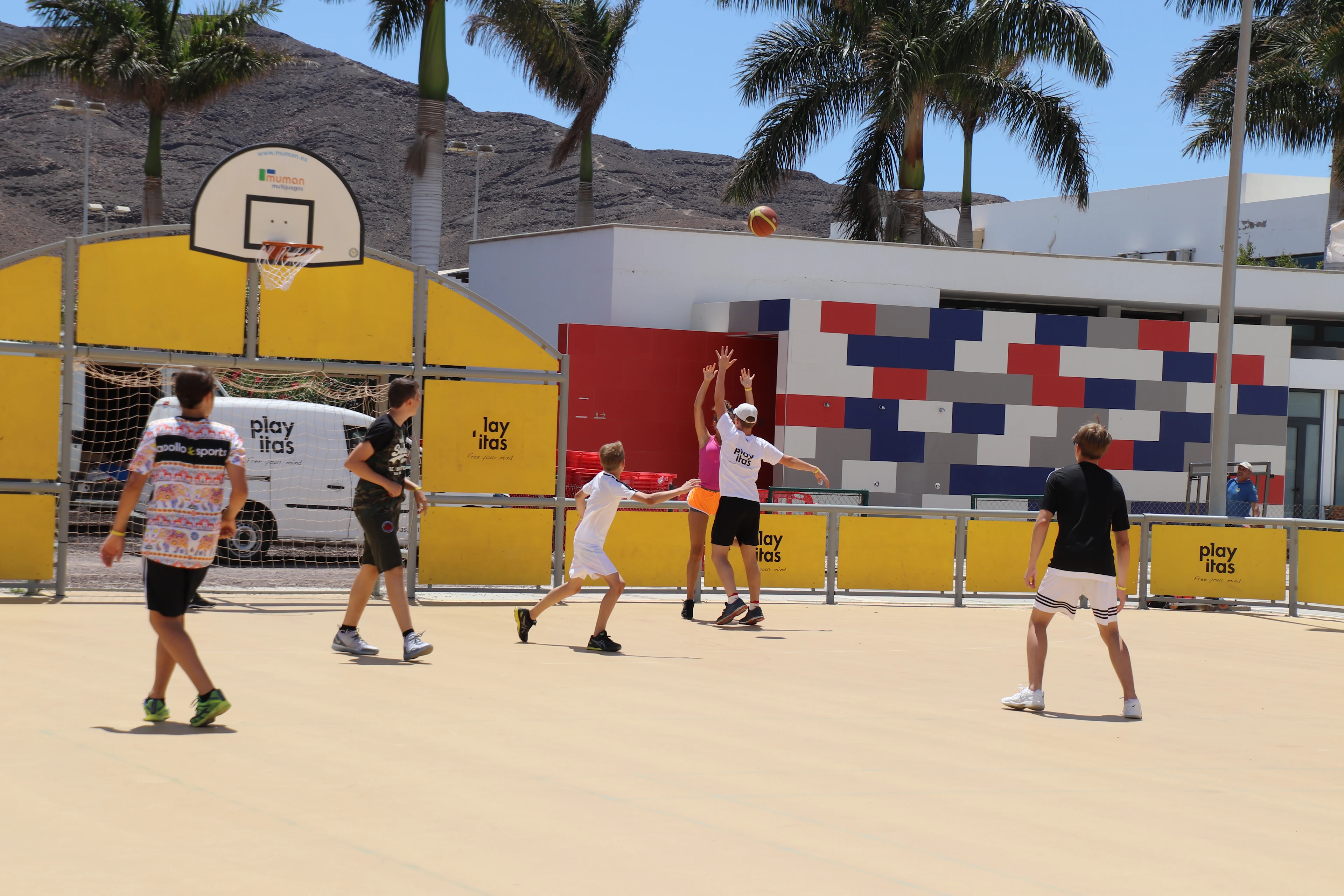 barn som spelar basket på en basketplan utomhus 