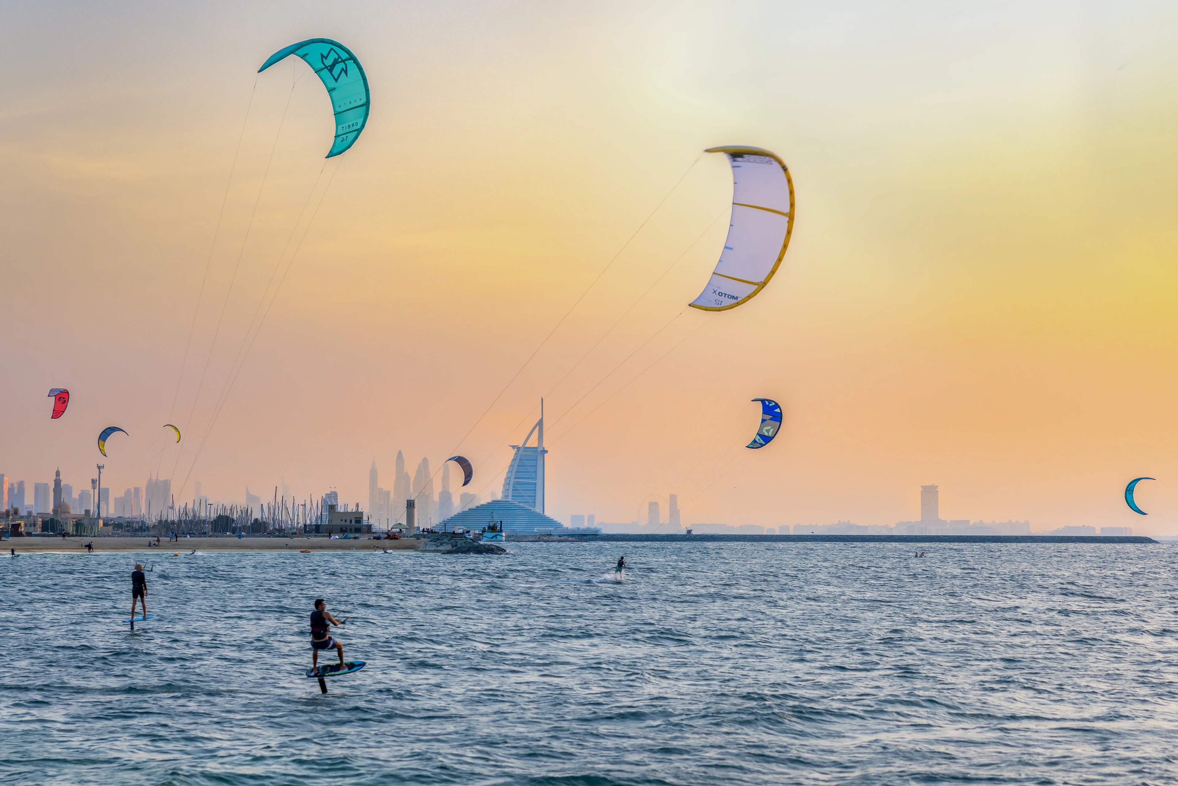 Kitesrufare vid Kite Beach i solnedgången i Dubai