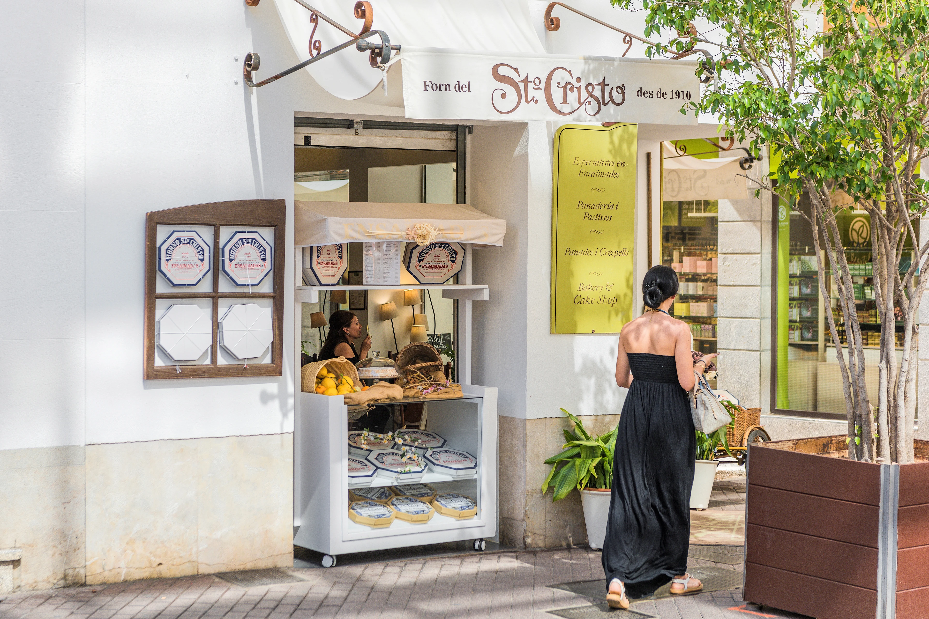 En kvinna som promenerar bland butiker i en mysig gränd på Mallorca
