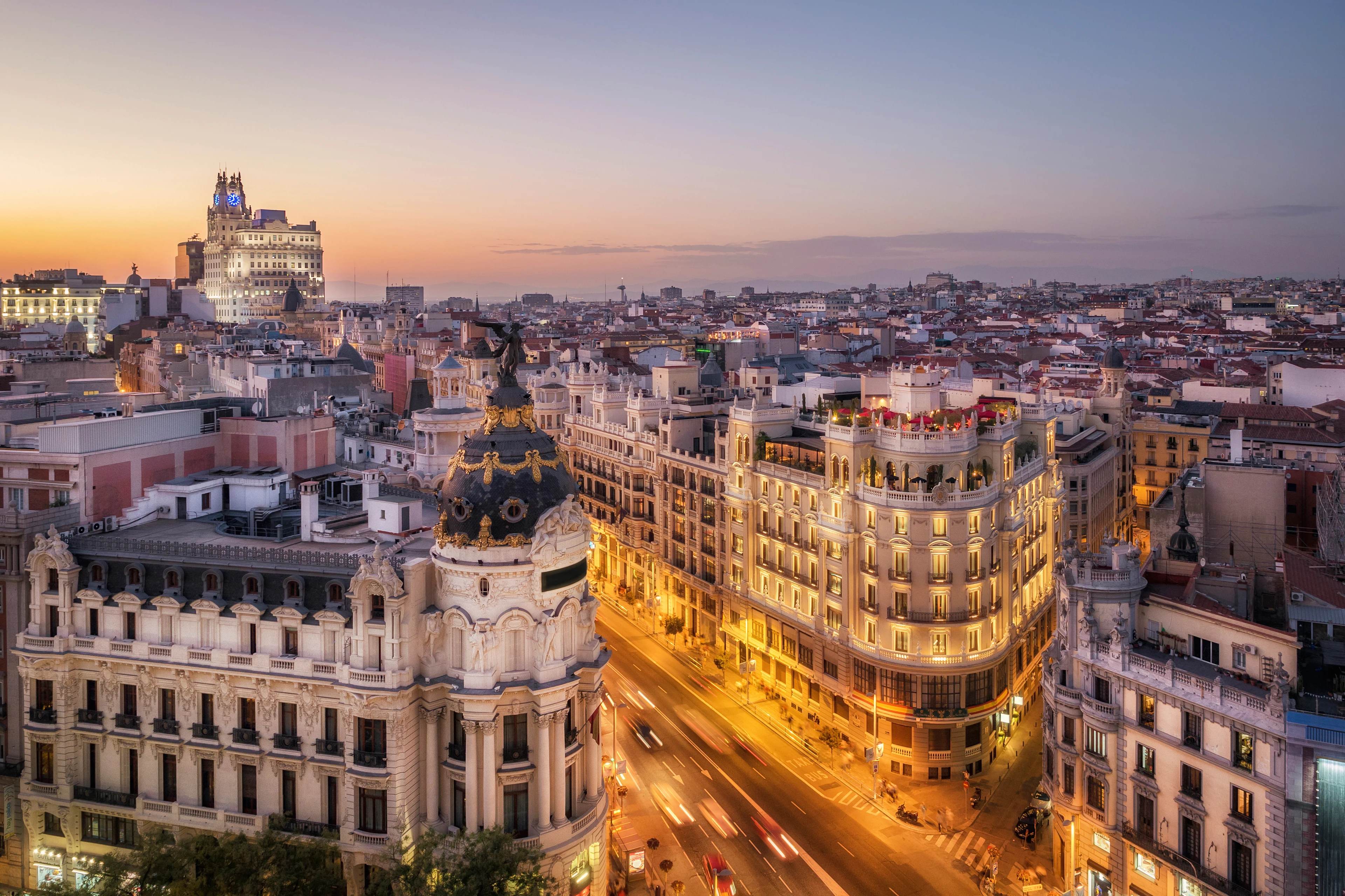Upplysta byggnader längs Gran Vía i Madrid vid solnedgången