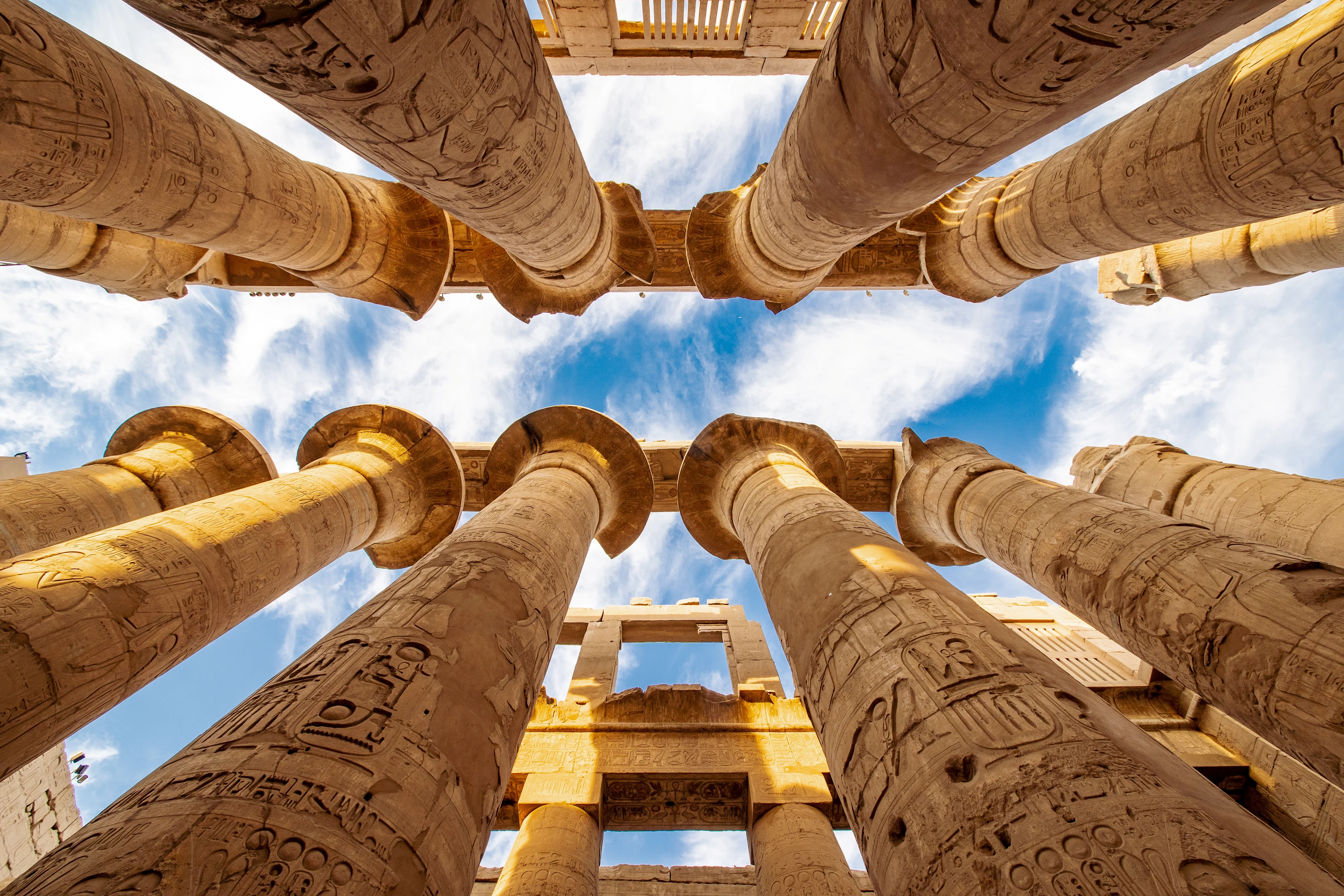 Søjlerne i Karnak-templet i Egypten, med høje stensøjler dekoreret med hieroglyffer under en klar blå himmel.