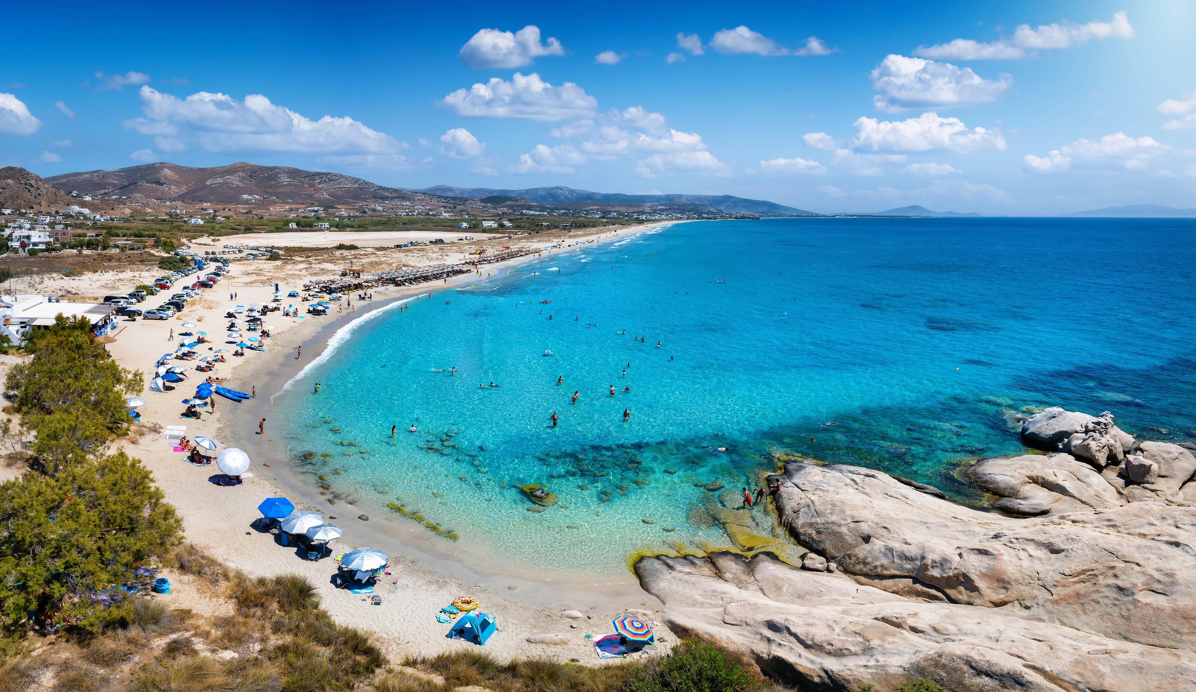 Människor som badar i det turkosa vattnet vid Mikri Vigla Beach på ön Naxos