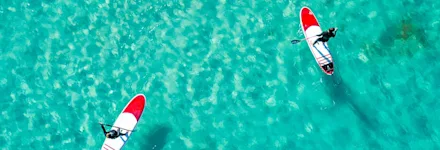 Personer med stand up paddle board i havet